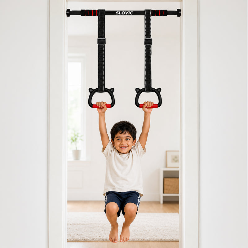 A young boy is shown using a wall-mounted pull-up bar with hanging rings in a bright, modern room. The pull-up bar is branded with the word 'SLOVIC' at the top center.