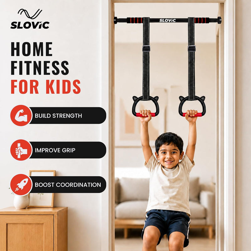 A child hanging from a wall-mounted pull-up bar set with two black straps and red handles, shown in a home interior. The left side includes the brand name SLOVIC, large text reading 'HOME FITNESS FOR KIDS,' and three benefit callouts about building strength, improving grip, and boosting coordination.
