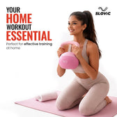 Woman exercising with a pink kettlebell on a white background, promoting home workout equipment.